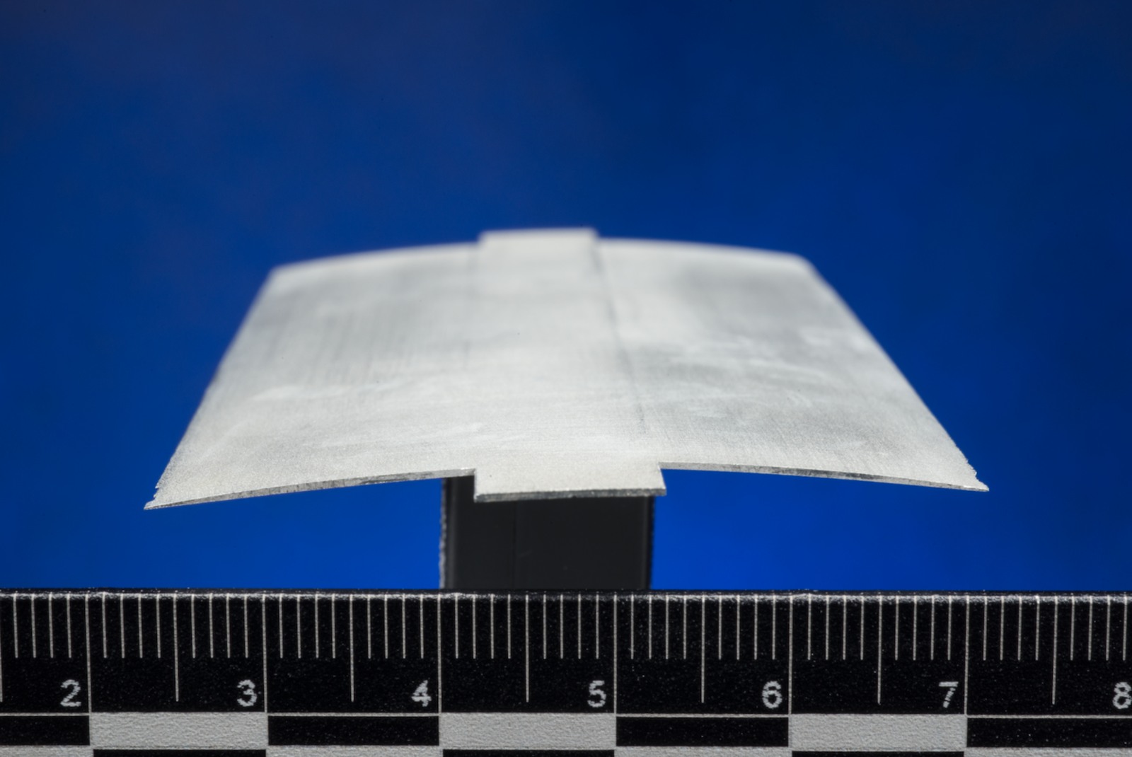 Laboratory view of an experimental rotor-blade cross-section beside a ruler. NASA image; this is test hardware, not a helicopter flying on Mars.