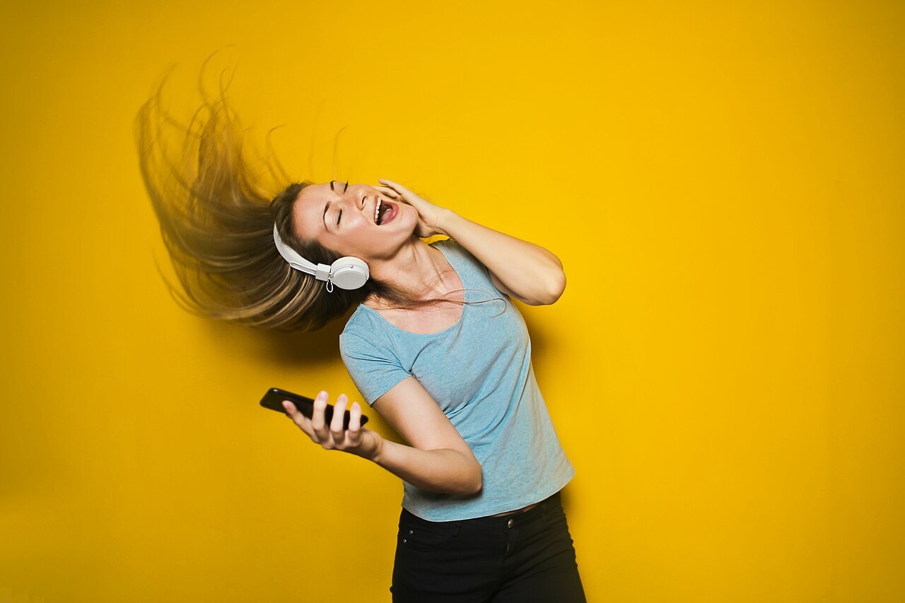 A woman listening to music through headphones. Illustrative file photograph, not an A&R Foundry participant or training session.