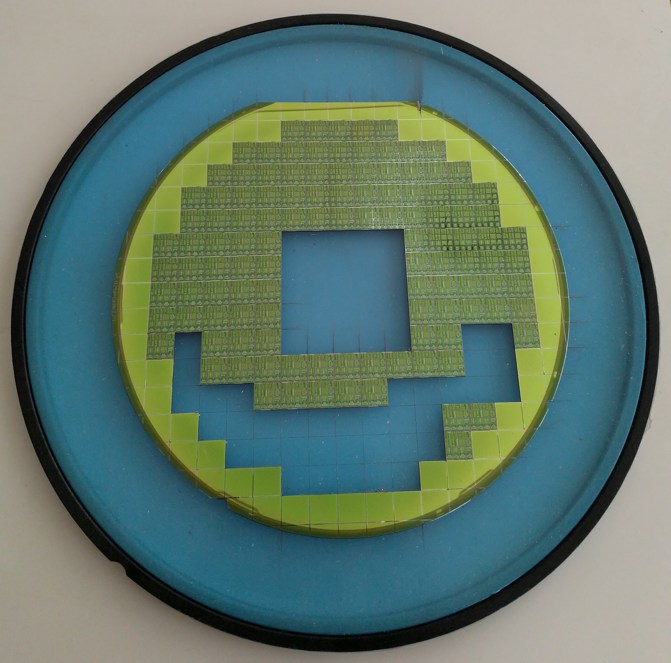 A semiconductor wafer on blue dicing tape, with some chips removed. Context photograph, not a Microsoft Maia chip.