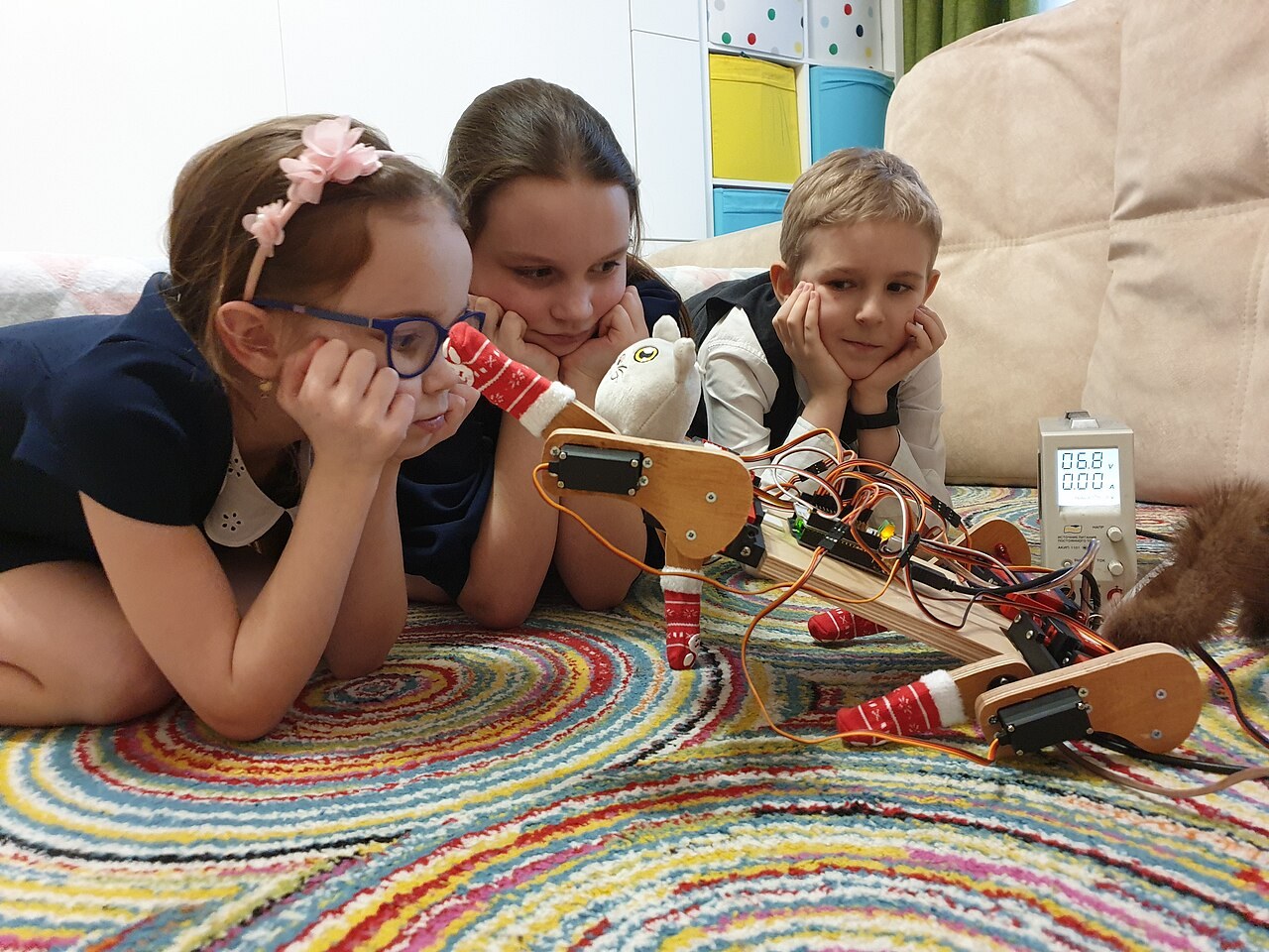 Students examine a robot cat they made. File photograph illustrating practical robotics learning; these are not participants in the proposed Nigerian pilot.